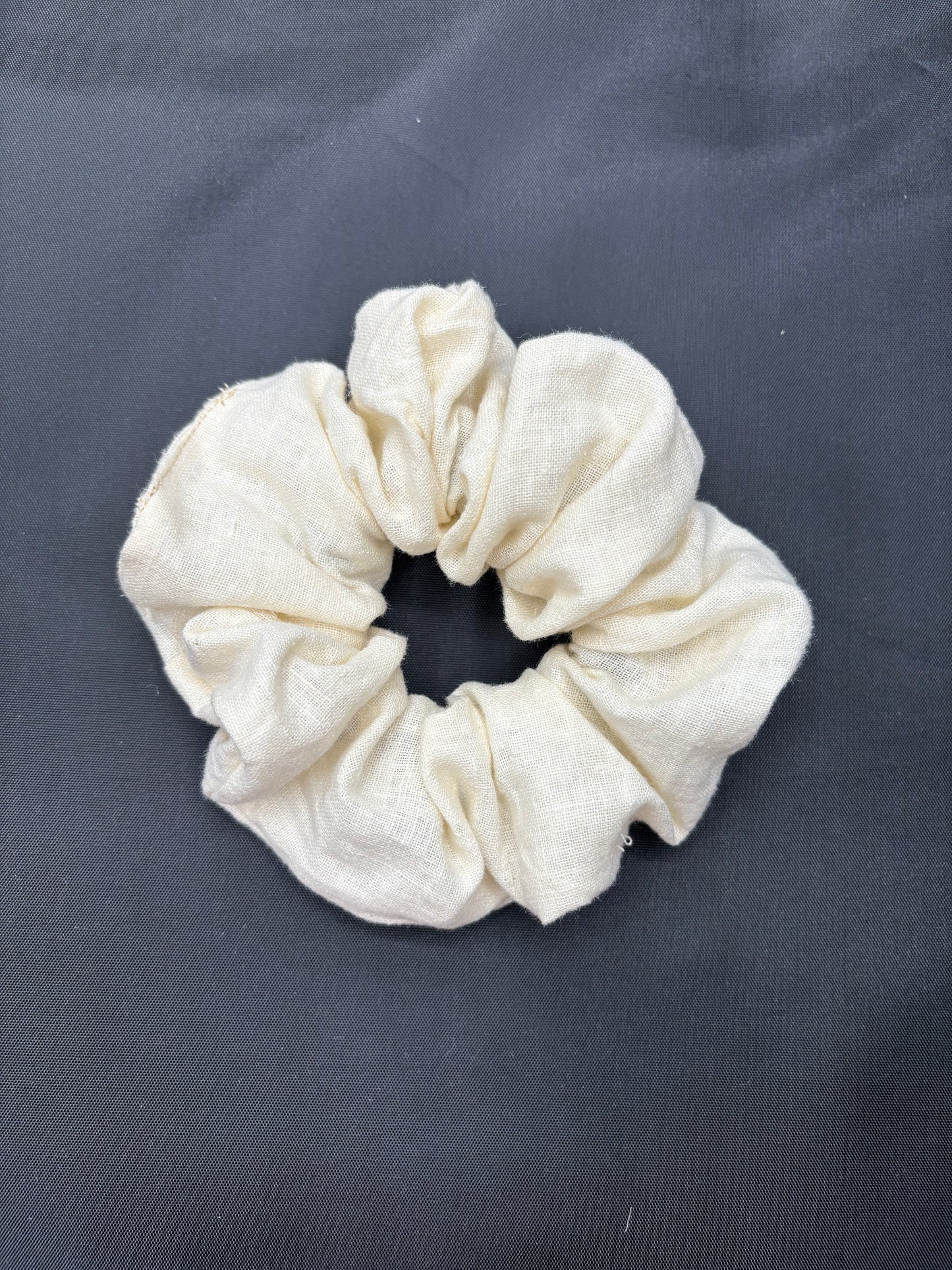White scrunchie on a dark gray background
